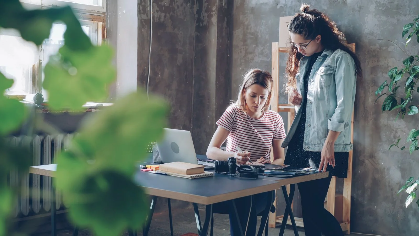 Deux jeunes professionnelles au travail dans un espace lumineux et végétal